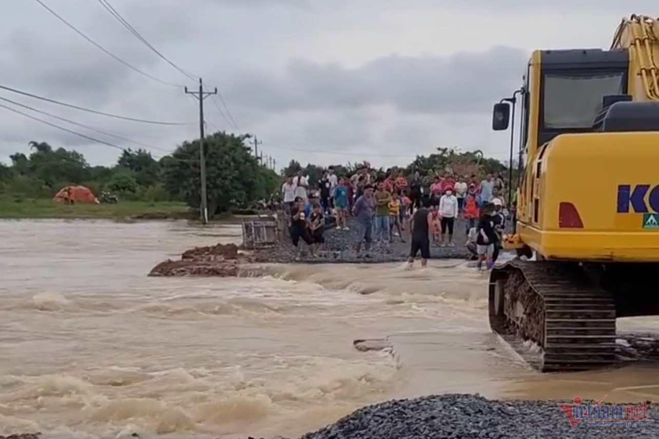 Tài xế gan dạ dùng máy xúc đưa người dân qua đoạn đường ngập